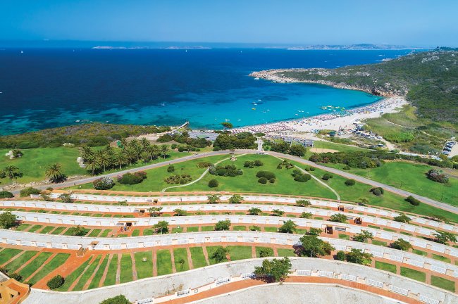 Vista panoramica di una spiaggia e prato verde.