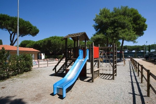 Parco giochi con scivolo blu e struttura di legno, cielo sereno.