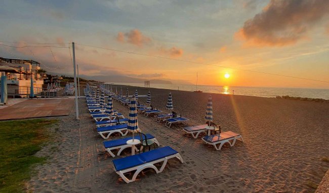 Lettini blu su una spiaggia al tramonto.
