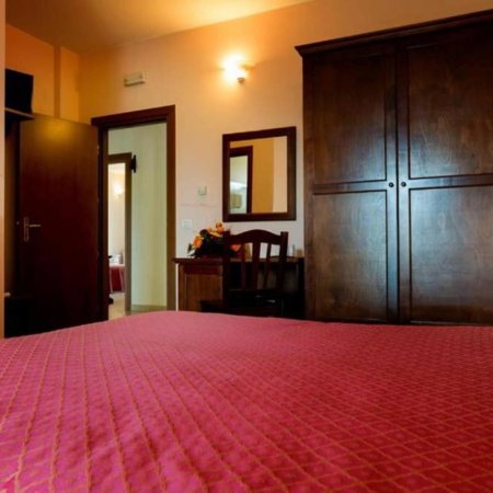 Camera con letto matrimoniale, armadio scuro e un tavolo con specchio.