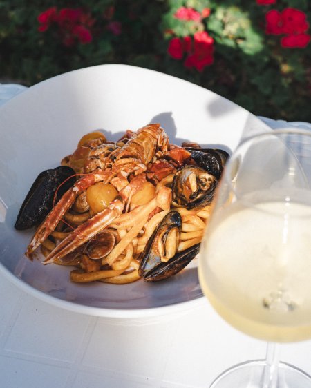 Piatto di pasta ai frutti di mare e vino.