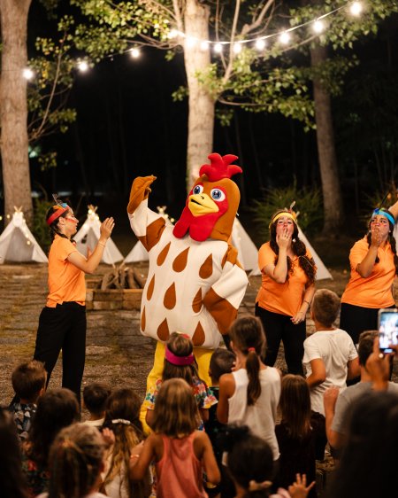 Persona in costume da gallina con bambini.
