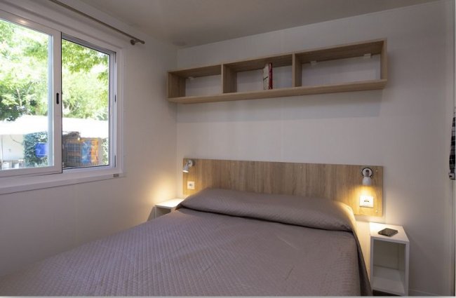 Camera da letto con letto matrimoniale e scaffale.