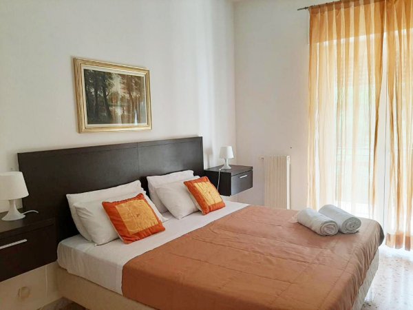 Camera da letto con letto matrimoniale e tende arancioni.