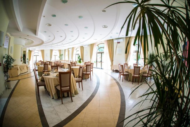 Sala da pranzo elegante con tavoli apparecchiati.