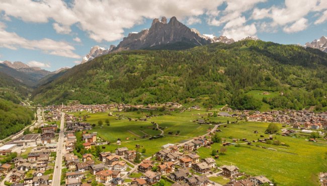 Villaggio alpino con montagne sullo sfondo.