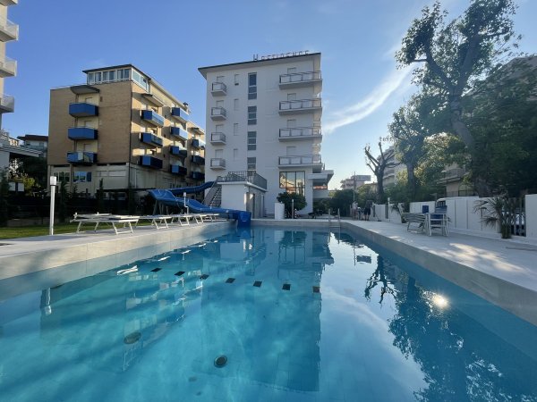 Piscina all'aperto con sedie a sdraio.