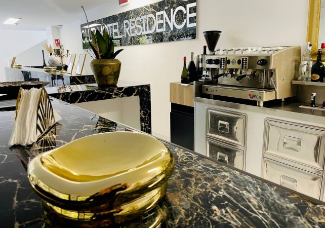 Banco bar in marmo nero con decorazioni dorate.