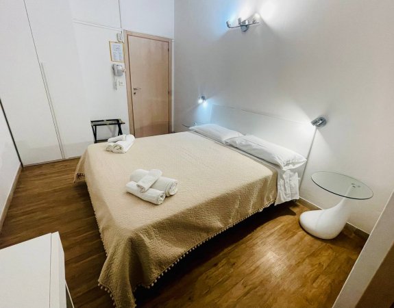 Stanza con letto matrimoniale e tavolino.