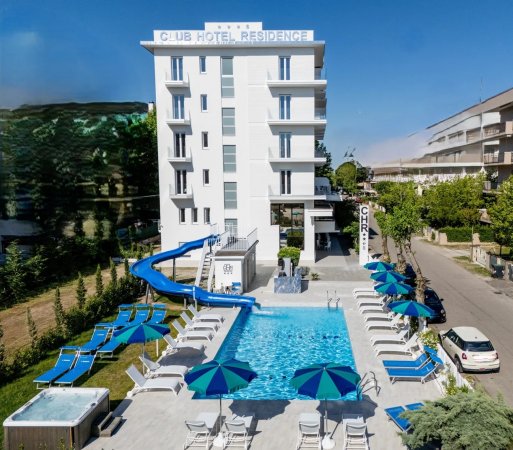 Hotel con piscina e scivolo, ombrelloni intorno.