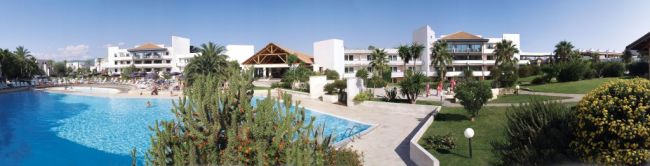 Resort con piscina blu e giardino curato.