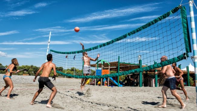 Persone che giocano a beach volley su una spiaggia.