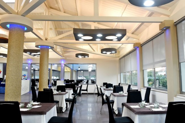 Ristorante moderno con tavoli apparecchiati e luci soffuse.