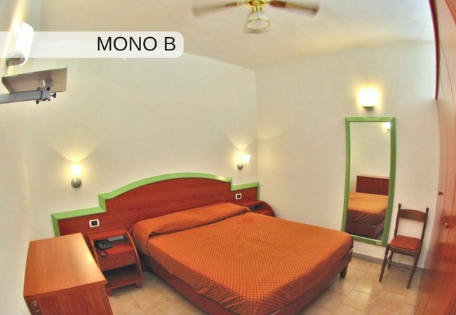 Camera con letto matrimoniale e specchio a parete.