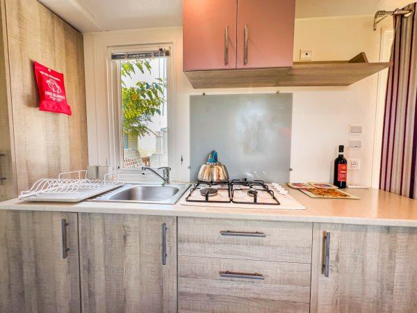 Lavello e fornelli accanto a finestra.