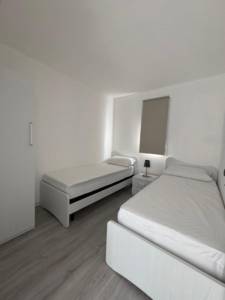 Due letti singoli in una stanza bianca.